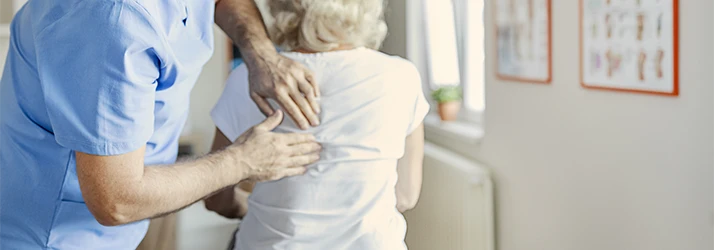An older woman receiving a back exam.
