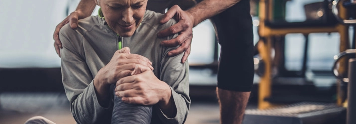 A woman holding her knee in pain.